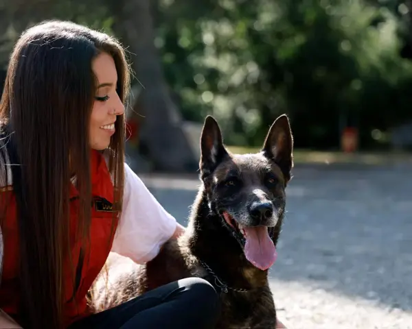 Una chica sonríe mientras acaricia a su perro, pero él parece ajeno, como si mi perro me ignorara.